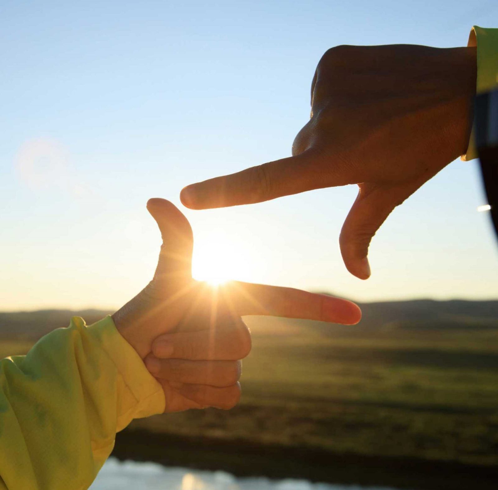 Human hands making a frame sign over sunset sky - RTO Homes
